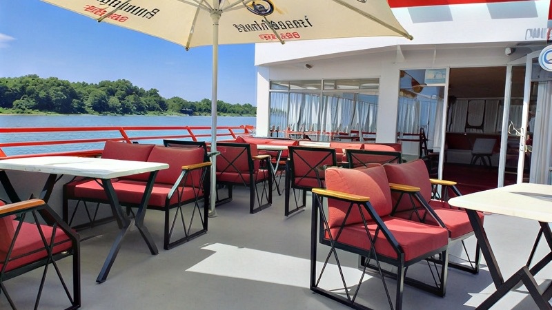 Sonnenterrasse an Bord mit roten Sesseln und Blick auf den Rhein